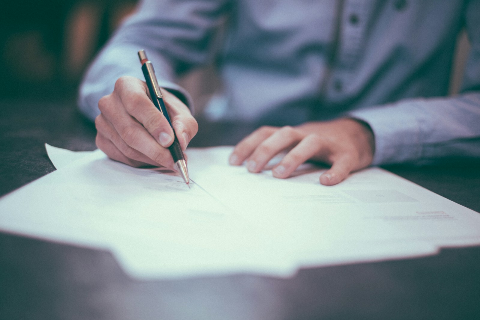 A person reviewing and writing on paper documents