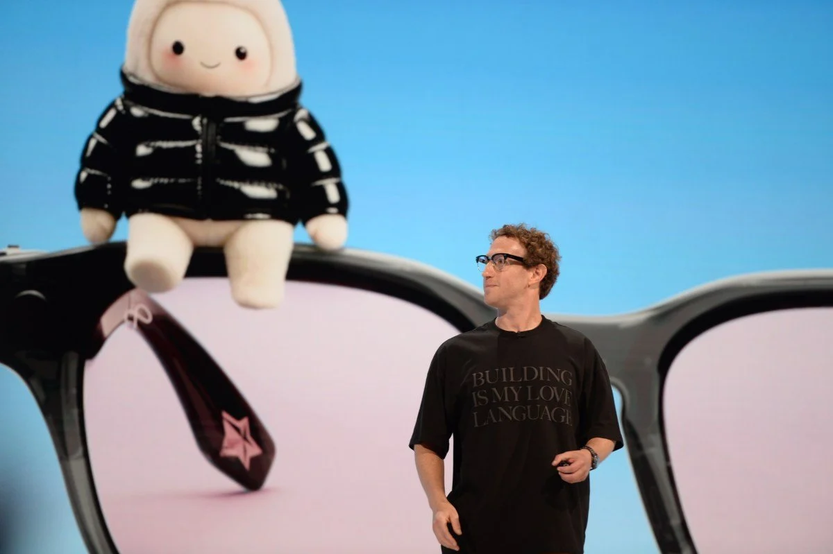 Mark Zuckerberg on stage beside a large character display.